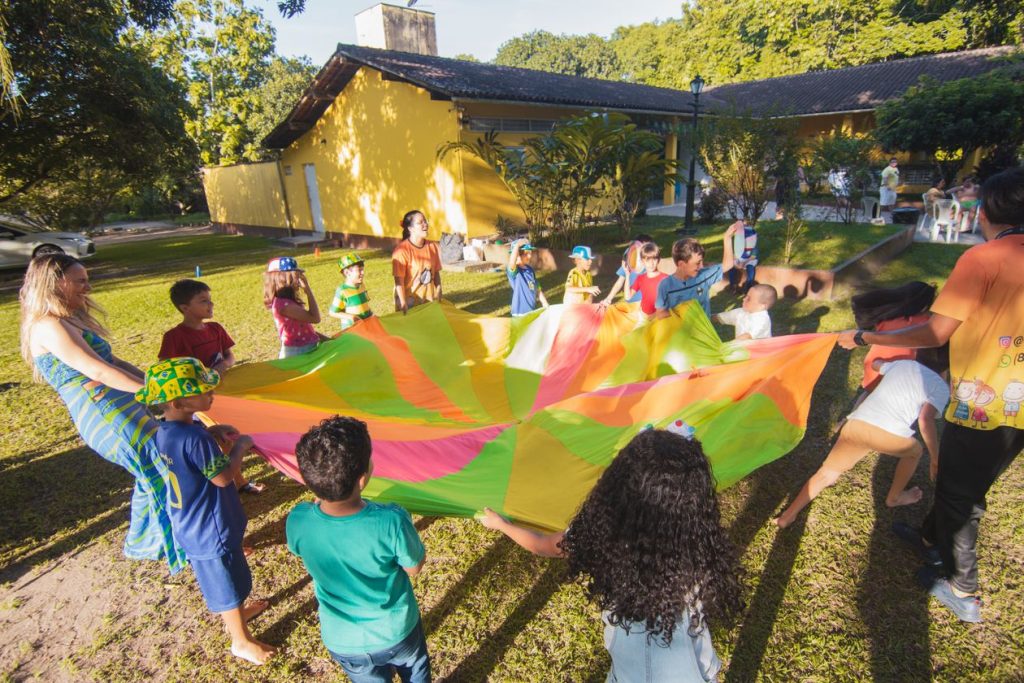 Children playing outdoors with a colourful parachute